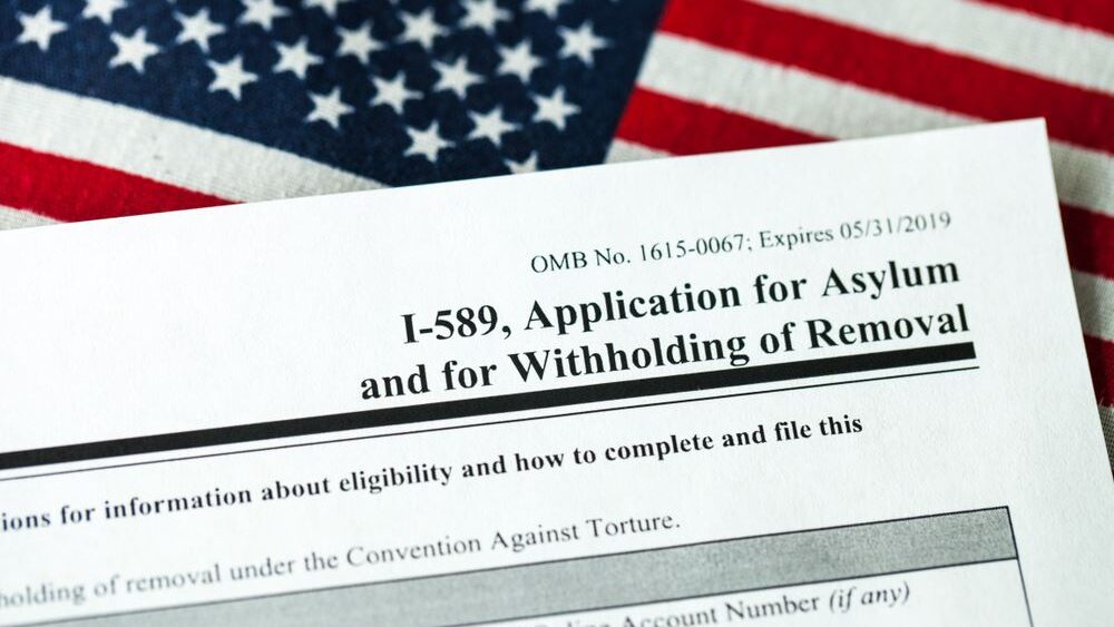 Close-up of Form I-589, Application for Asylum and for Withholding of Removal, resting on a U.S. flag