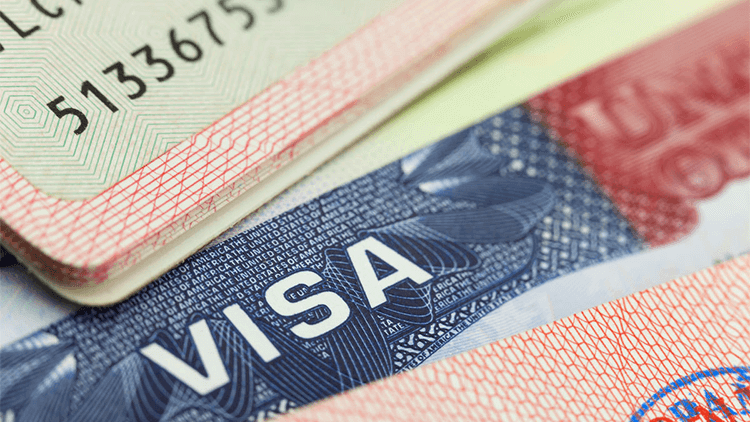 Close-up de páginas de passaporte dos Estados Unidos, destacando um visto americano com elementos de segurança e carimbos de entrada.