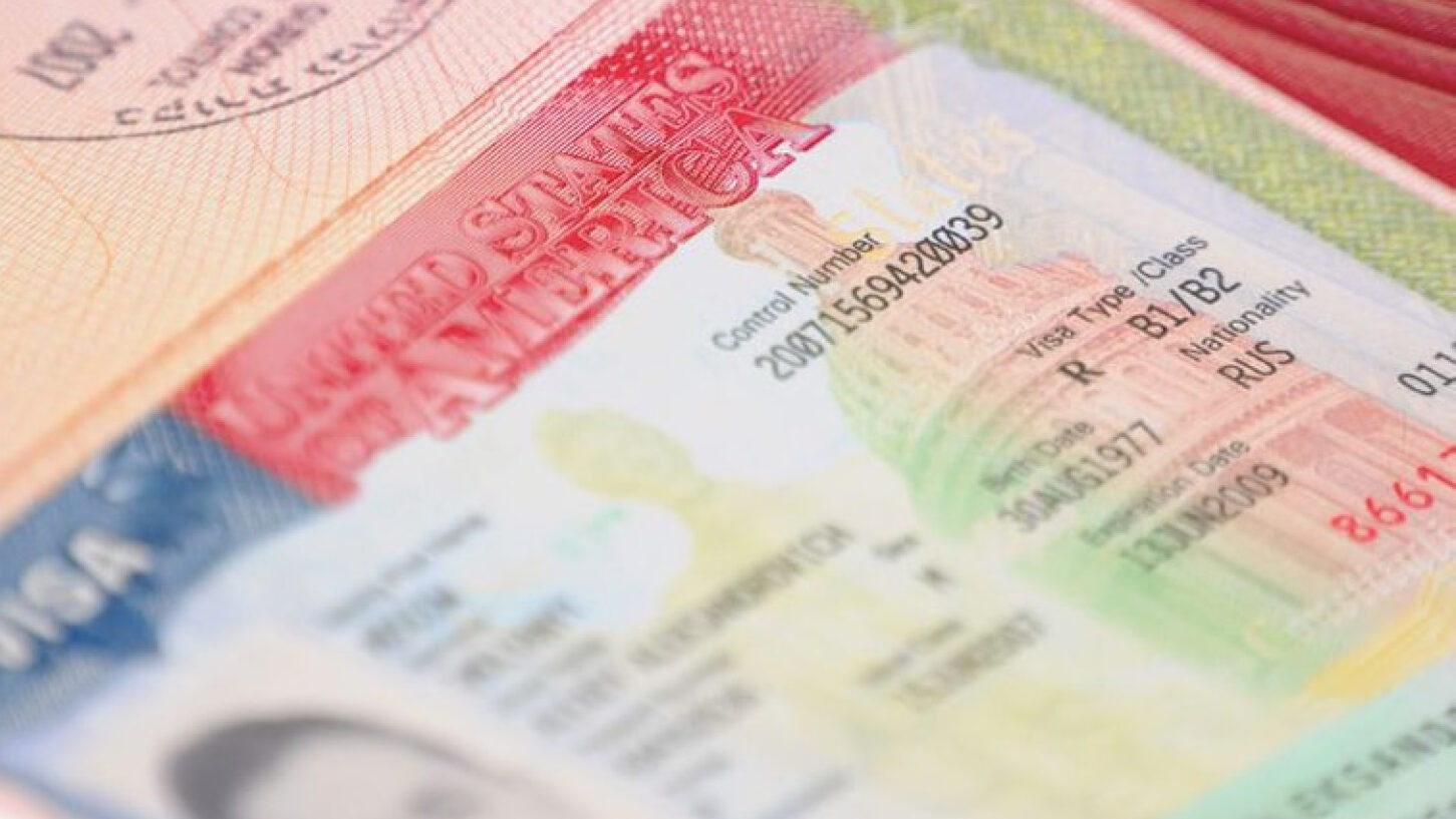 Close-up image of a U.S. visa document and passport page showing visa details, including a B1/B2 visitor visa classification.